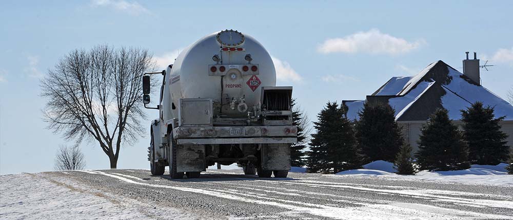Truck delivering propane to residential home in winter