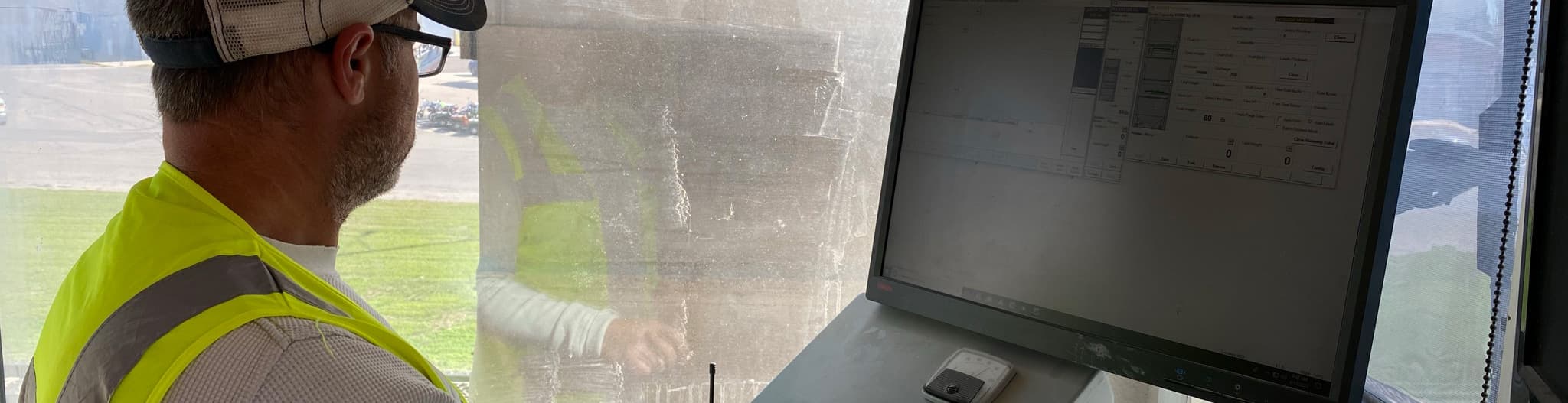 Man sitting in tractor looking at software on a screen