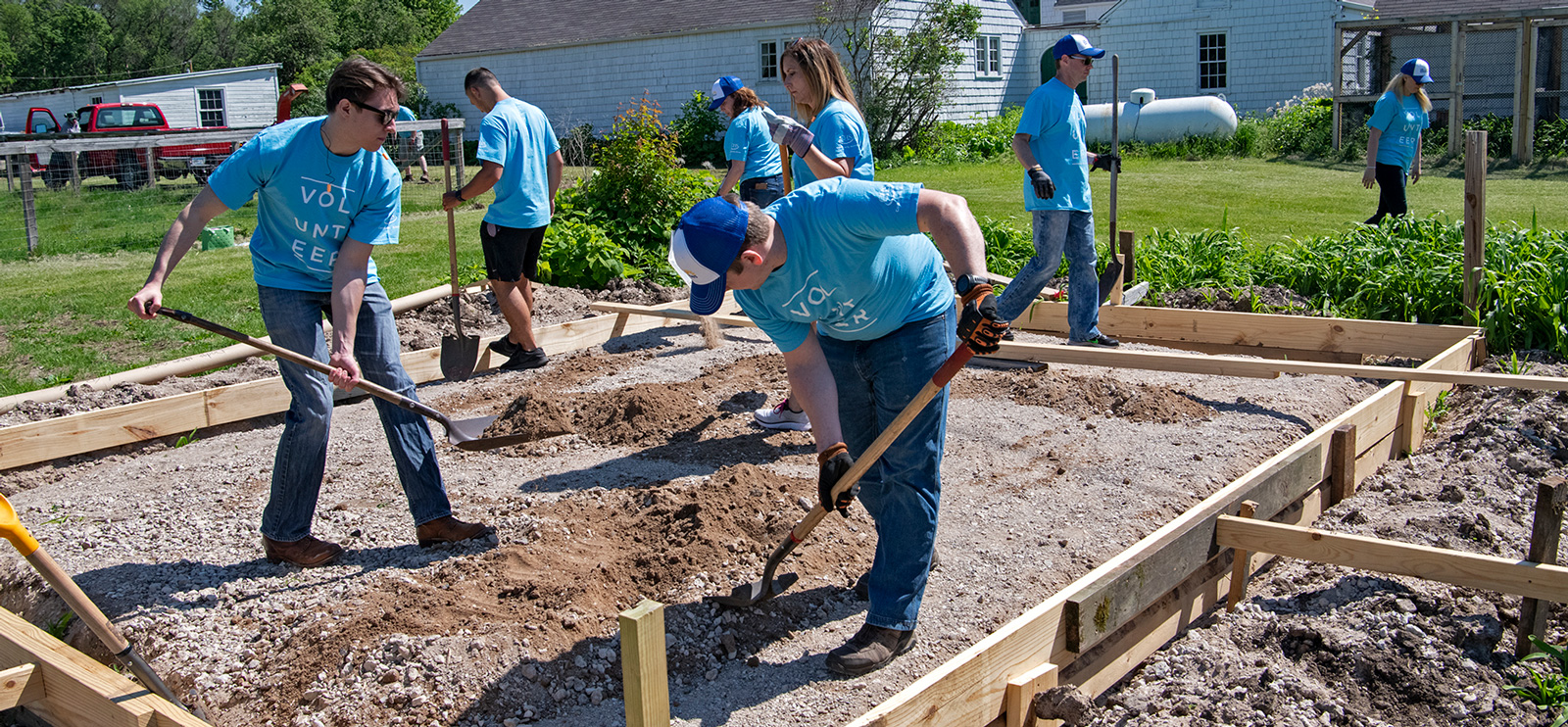 Group of volunteers digging up a garden plot