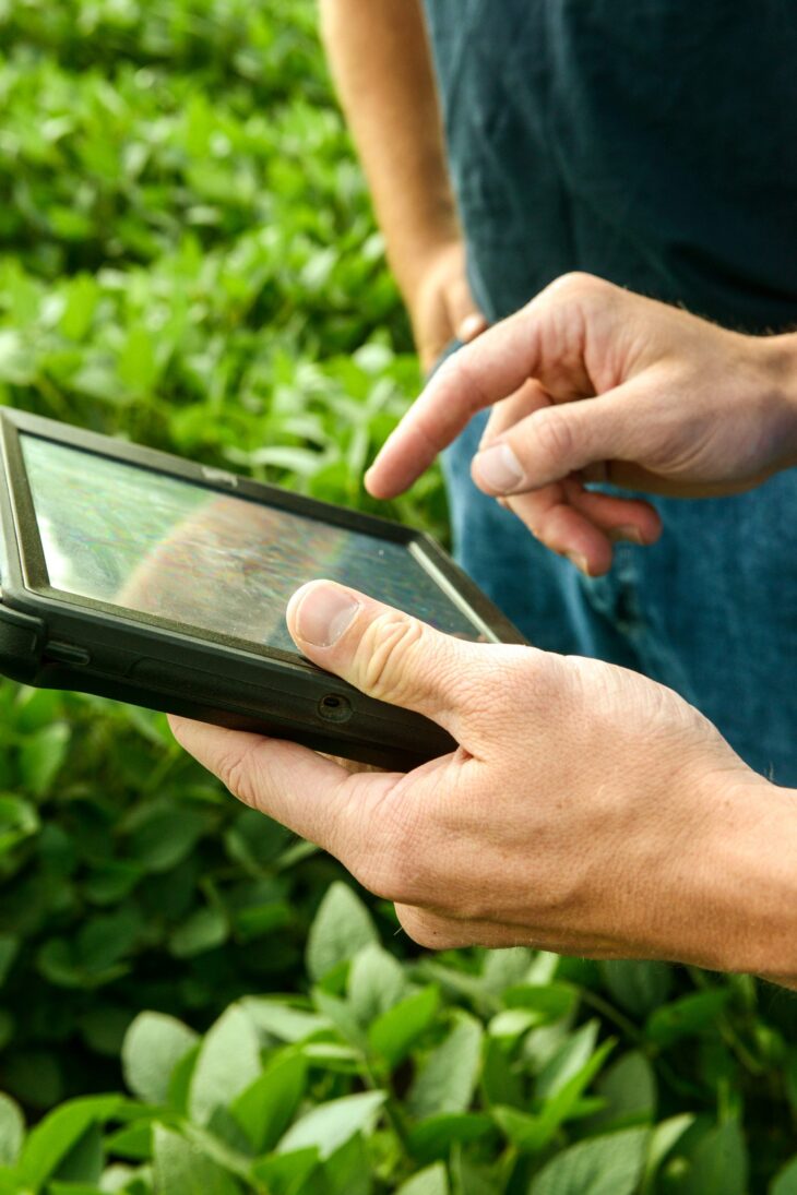 Hands holding tablet showing precision ag technology
